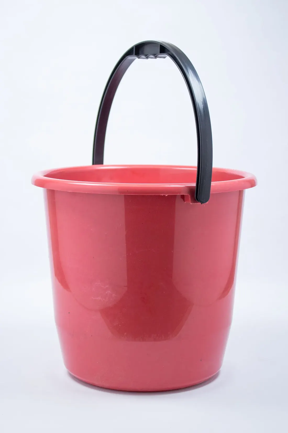Single pink cleaning bucket photographed against a plain background