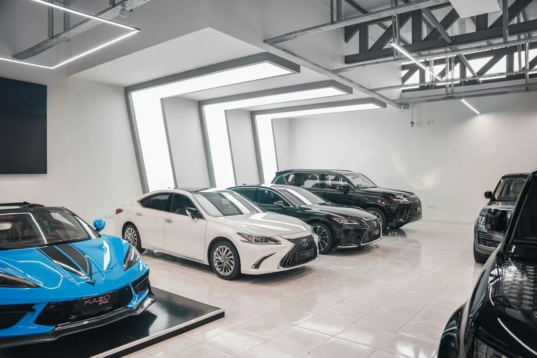 Dealership showroom floor lit above a line of new vehicles