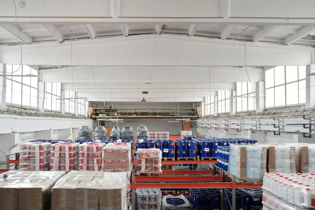Warehouse floor stacked with palletised inventory under skylights