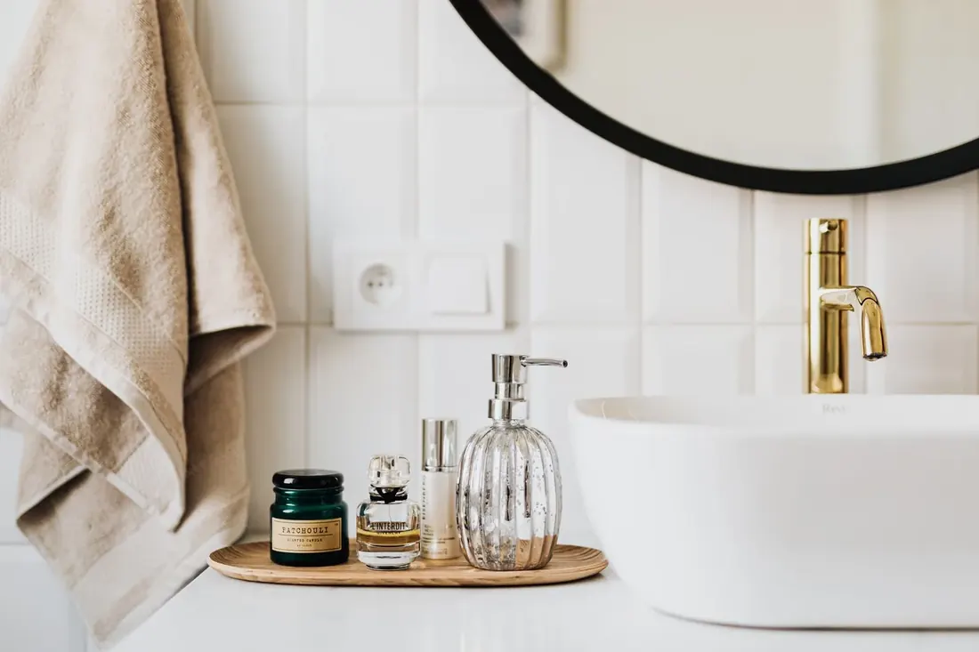 Bathroom vanity styled with a soap dispenser and folded towel